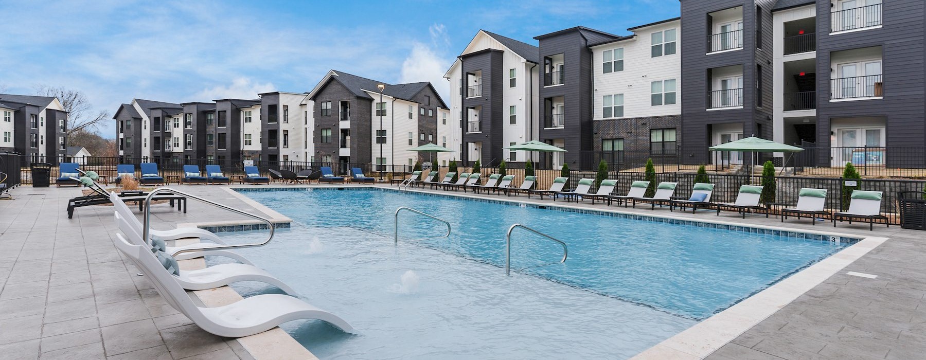 resort style pool with seating and a building behind