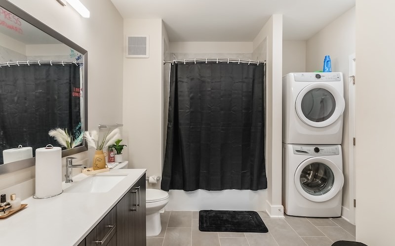 bathroom with shower sink mirror and washer and dryer